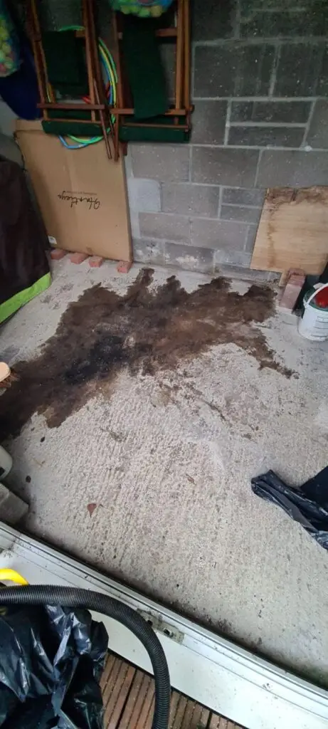 A dark chemical spill on the floor of a garage.