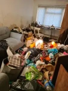 A small room in a domestic property full of furniture and hoarding waste.