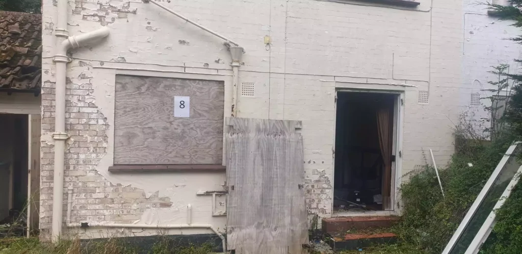 A derelict domestic property with boarded up windows in Elstree.