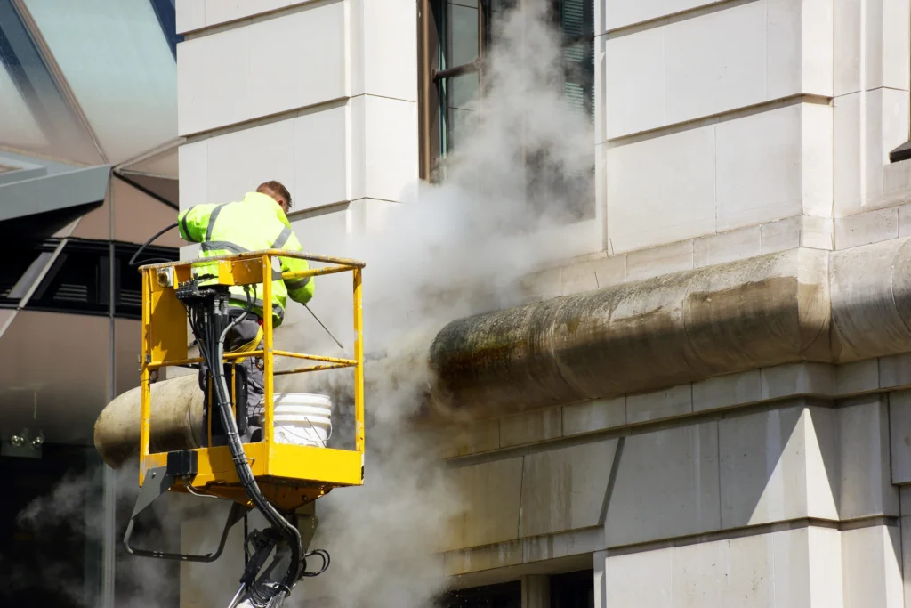 Technician on a remote access tool performing building exterior cleaning with a DOFF system.
