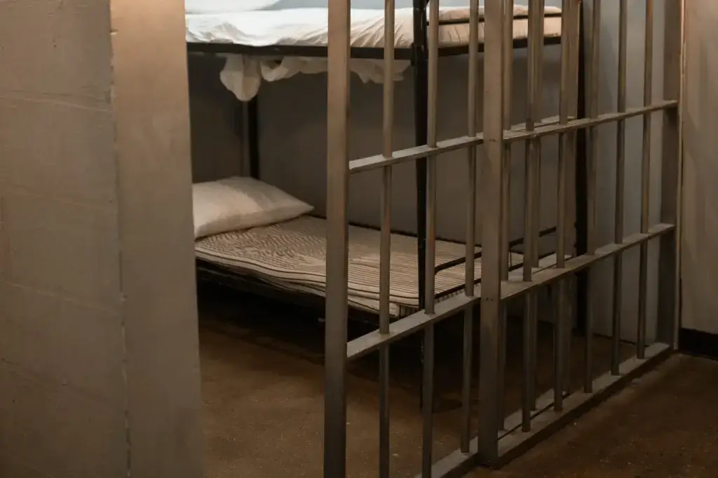 A well cleaned open prison cell with a bunk bed.