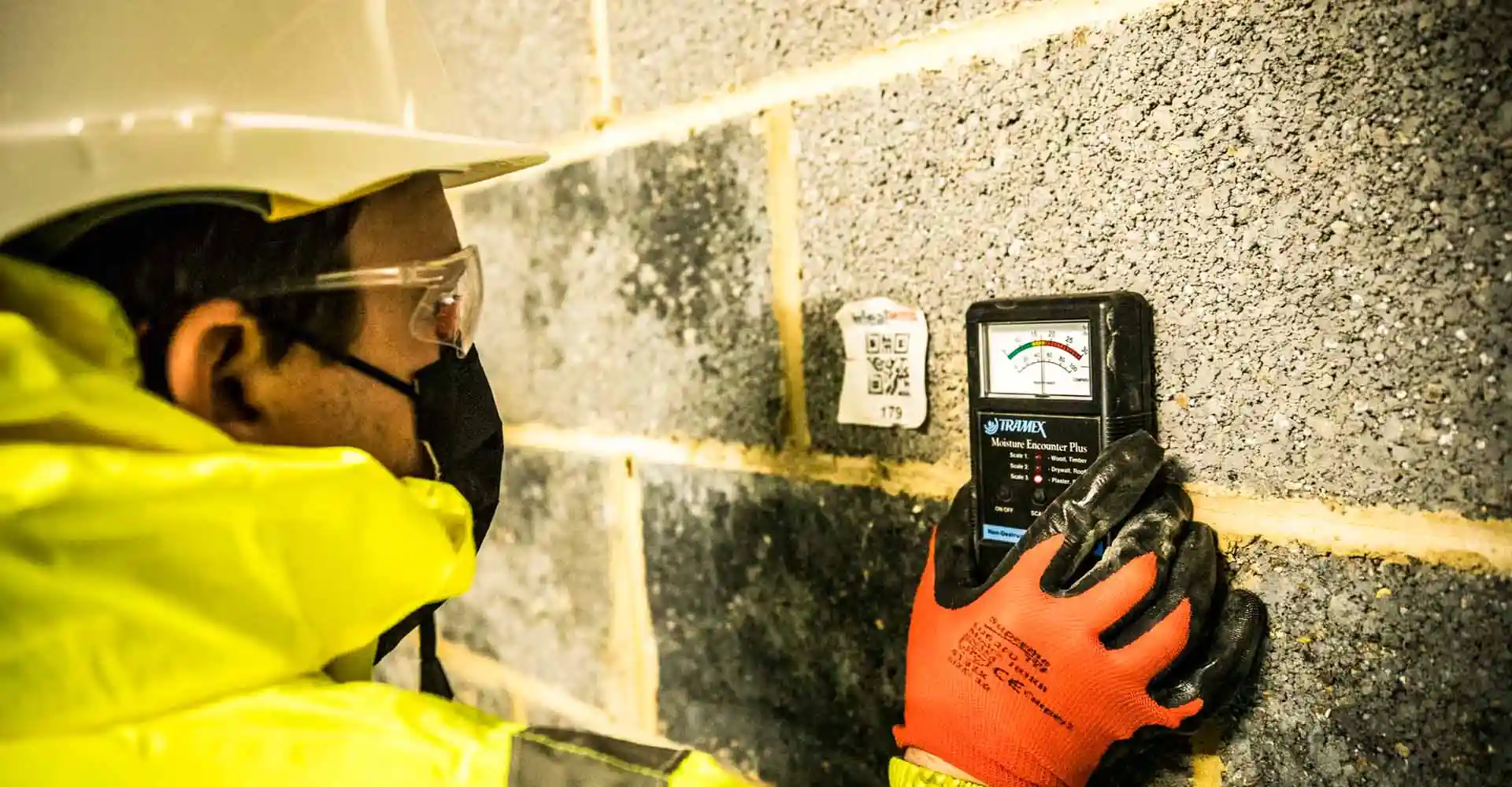 Ideal Response technician taking a moisture reading from a wall