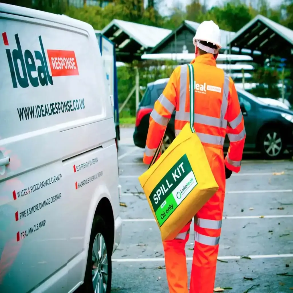 Person in PPE carrying an oil spill kit