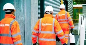 Three technicians in high visibility Ideal Response branded uniforms and PPE.
