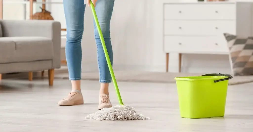 Woman mopping the floor of her home after a sewage spill.