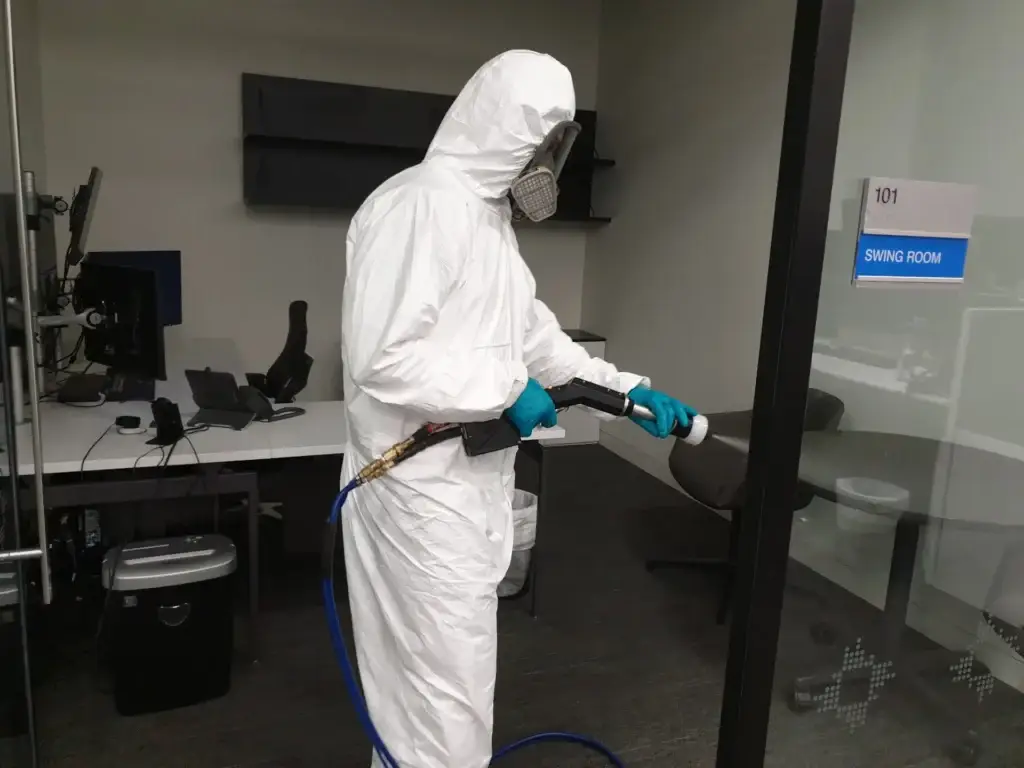 Technician decontaminating an office