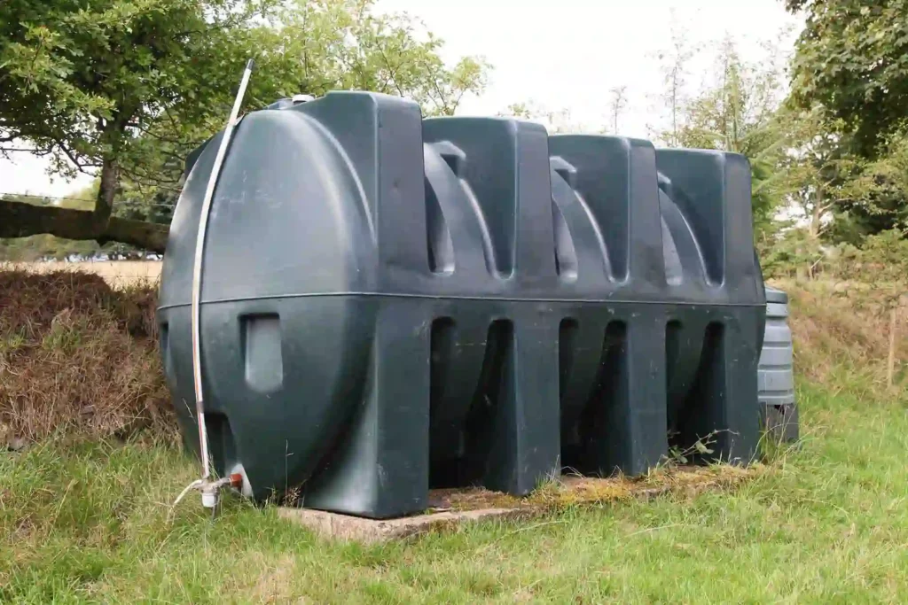 Large green heating oil tank outside of a UK home.