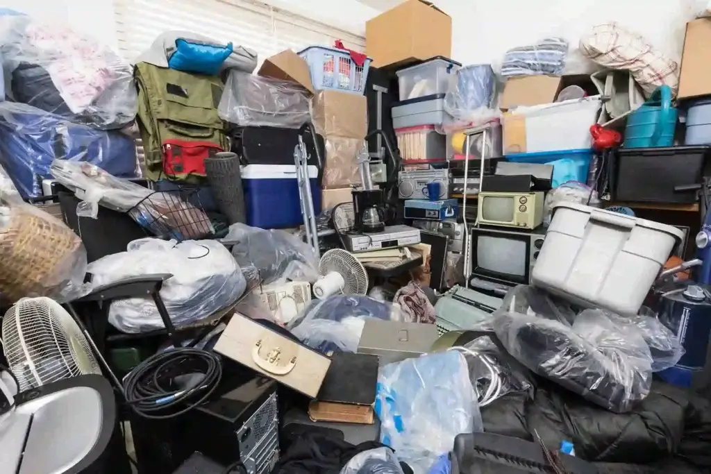 Bedroom full of hoard that consists of old electronics and boxes.