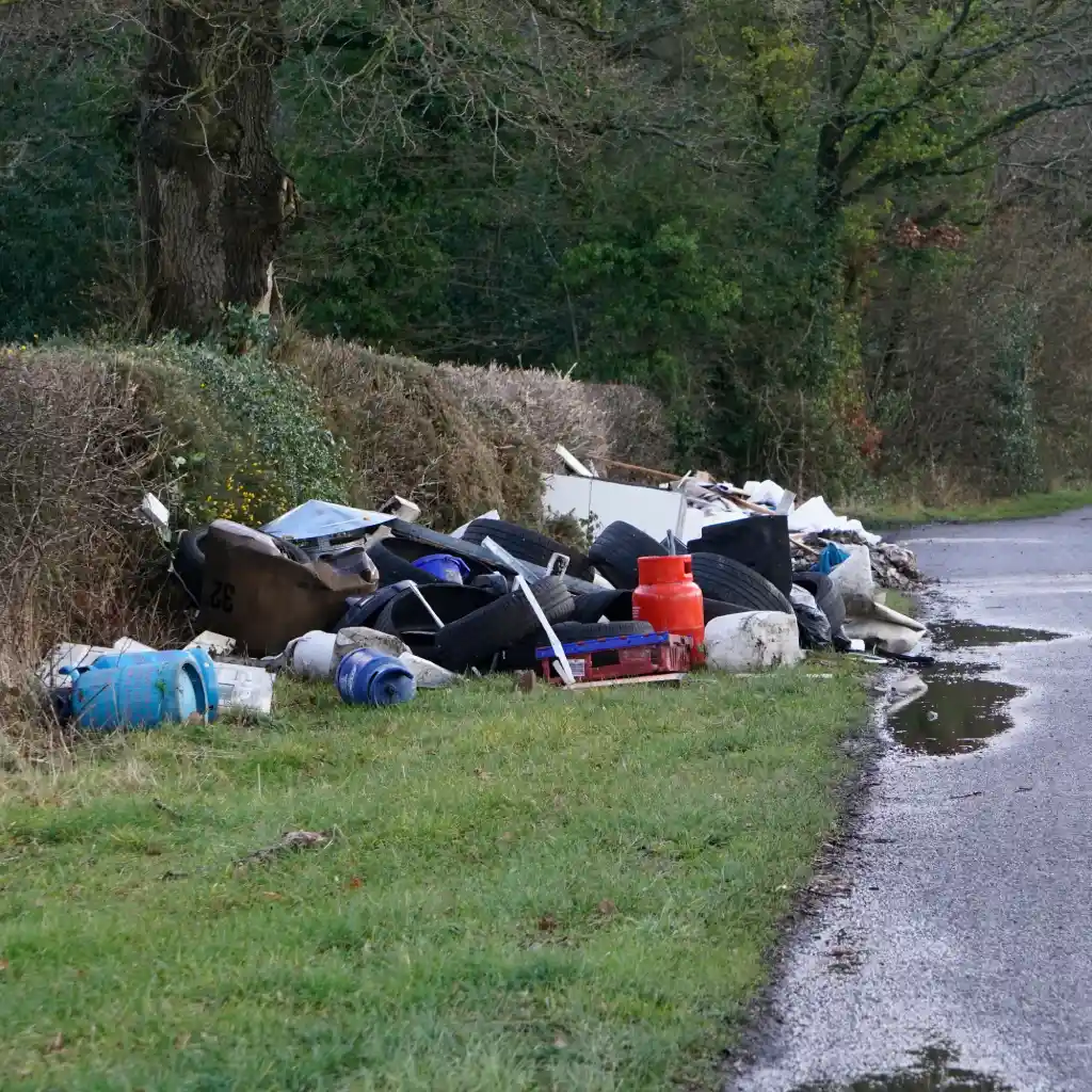 Fly tipped waste at the side of a road in the UK