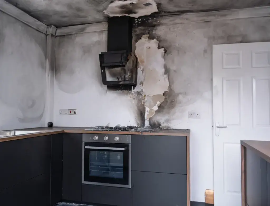 A home kitchen following a fire, covered is soot and smoke damage
