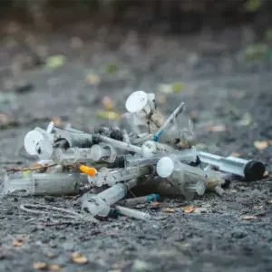 A pile of used syringes outside of a building