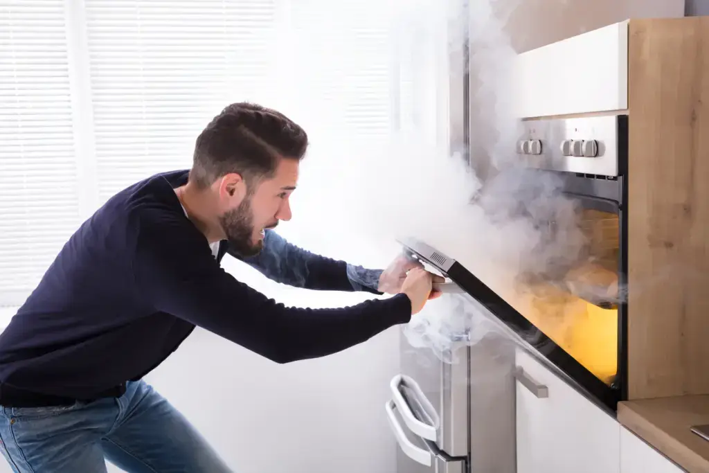 Man opening oven as it is on fire
